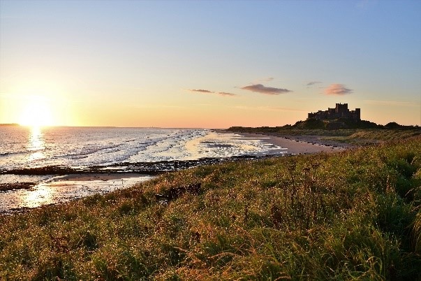 Sunrise at the Northumberland Coast with Bamburgh Castle overlooking the beach. This is an AONB in England. 